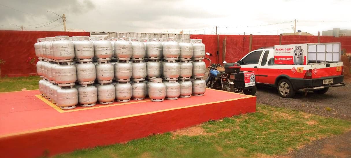 Pátio da Ética Gás em Ponta Porã com botijões de 13 kg estocados e os carros de entrega